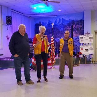 Three people are standing next to each other in a room.