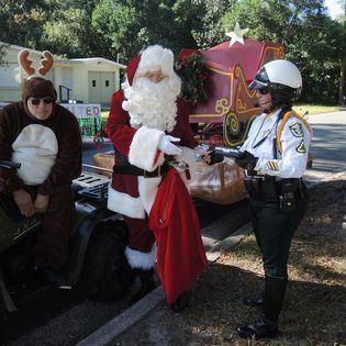 A man dressed as a reindeer is standing next to a man dressed as santa claus