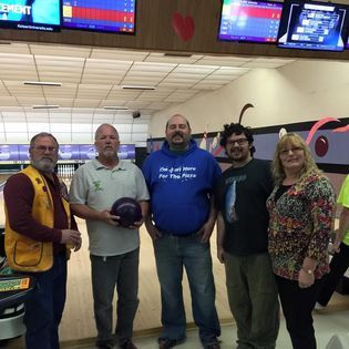 A group of people are posing for a picture at a bowling alley