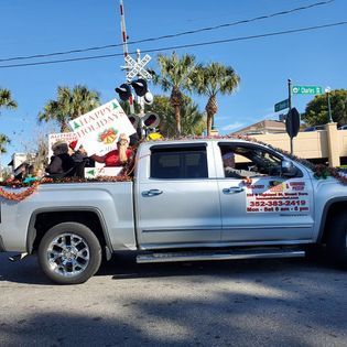 A silver truck with a sign on top that says happy holidays
