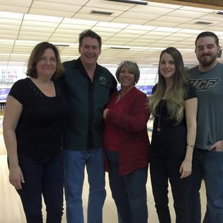 A group of people posing for a picture in a bowling alley