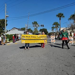 Two women are holding a sign that says the rich critter foundation.