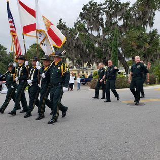 A group of police officers marching down a street holding flags