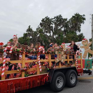 A gingerbread man is on a float in a parade.