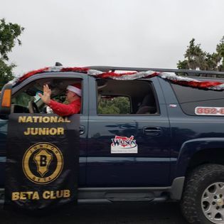 A man in a santa hat is sitting in a blue beta club vehicle