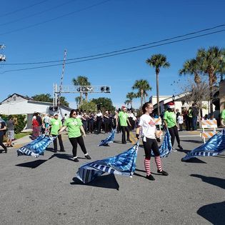 A group of people are marching down a street holding flags.
