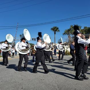 A marching band is marching down a street in a parade.