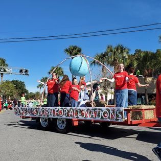 A group of people on a float that says news for all nations