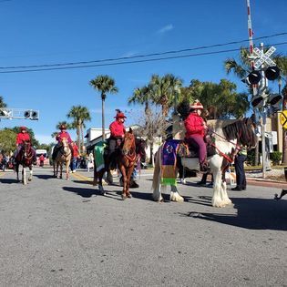 A group of people riding horses down a street