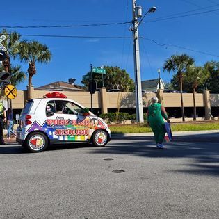 A woman is crossing the street in front of a sports car.