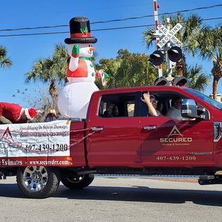A red truck with an inflatable snowman in the back