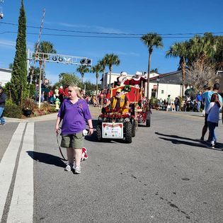 A group of people are walking down a street in front of a parade.
