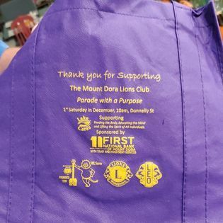 A purple bag that says thank you for supporting the mount dora lions club
