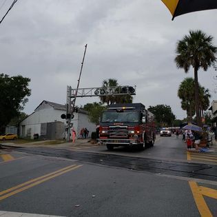 A fire truck is driving down a street in the rain