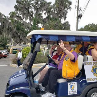 A group of people are riding in a golf cart.