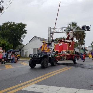 Santa claus is riding in a sleigh in a parade.