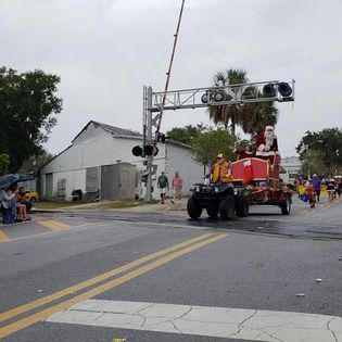 Santa claus is riding on the back of an atv in a parade.