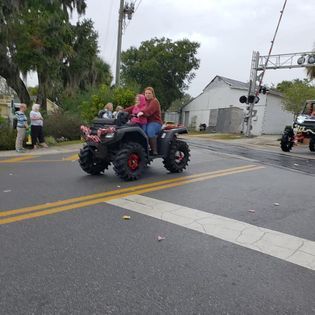 A group of people are riding an atv down a street.