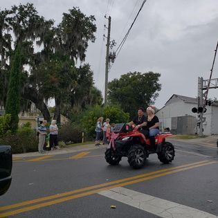 A group of people are riding an atv down a street.