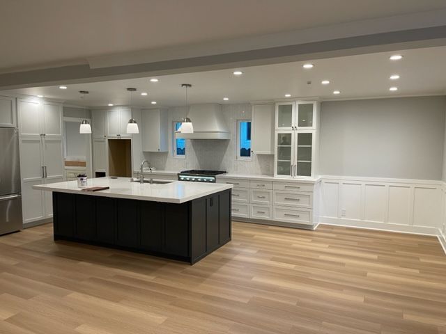 A kitchen with a large island and stainless steel appliances.