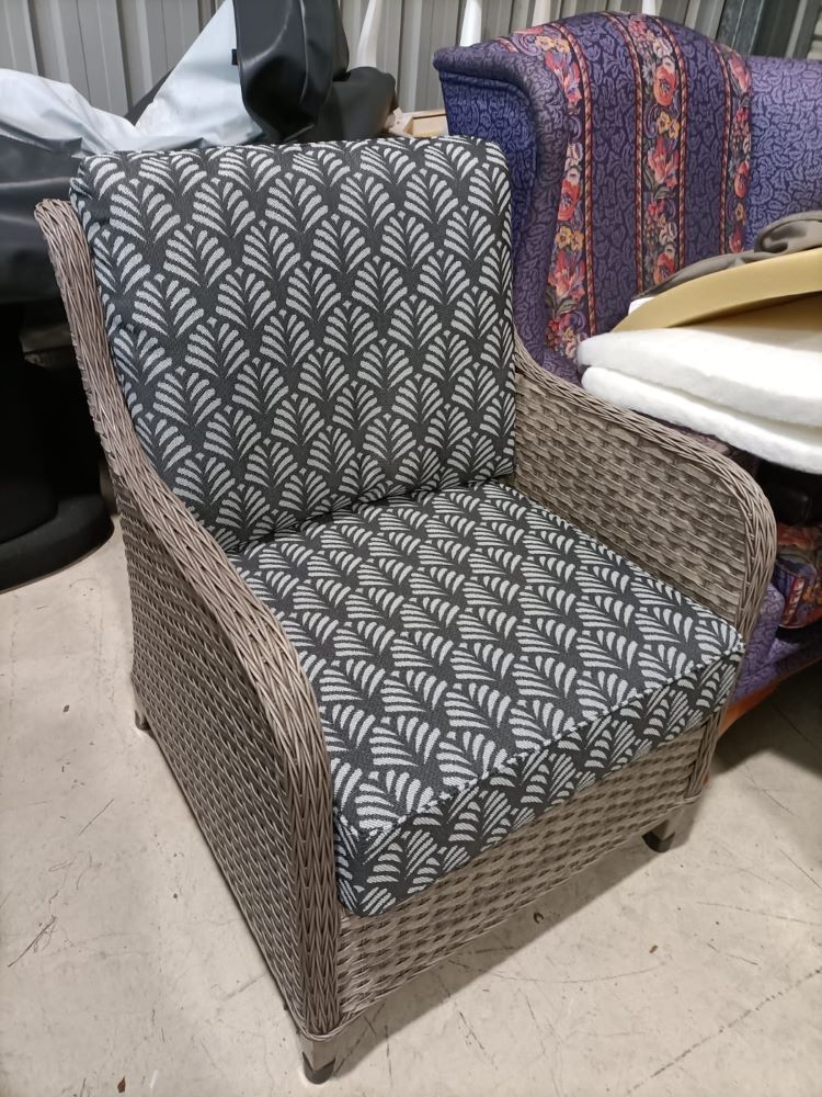 A Wicker Chair With A Patterned Cushion Is Sitting In A Room  — Ocean Charm Upholstery In Southport, QLD
