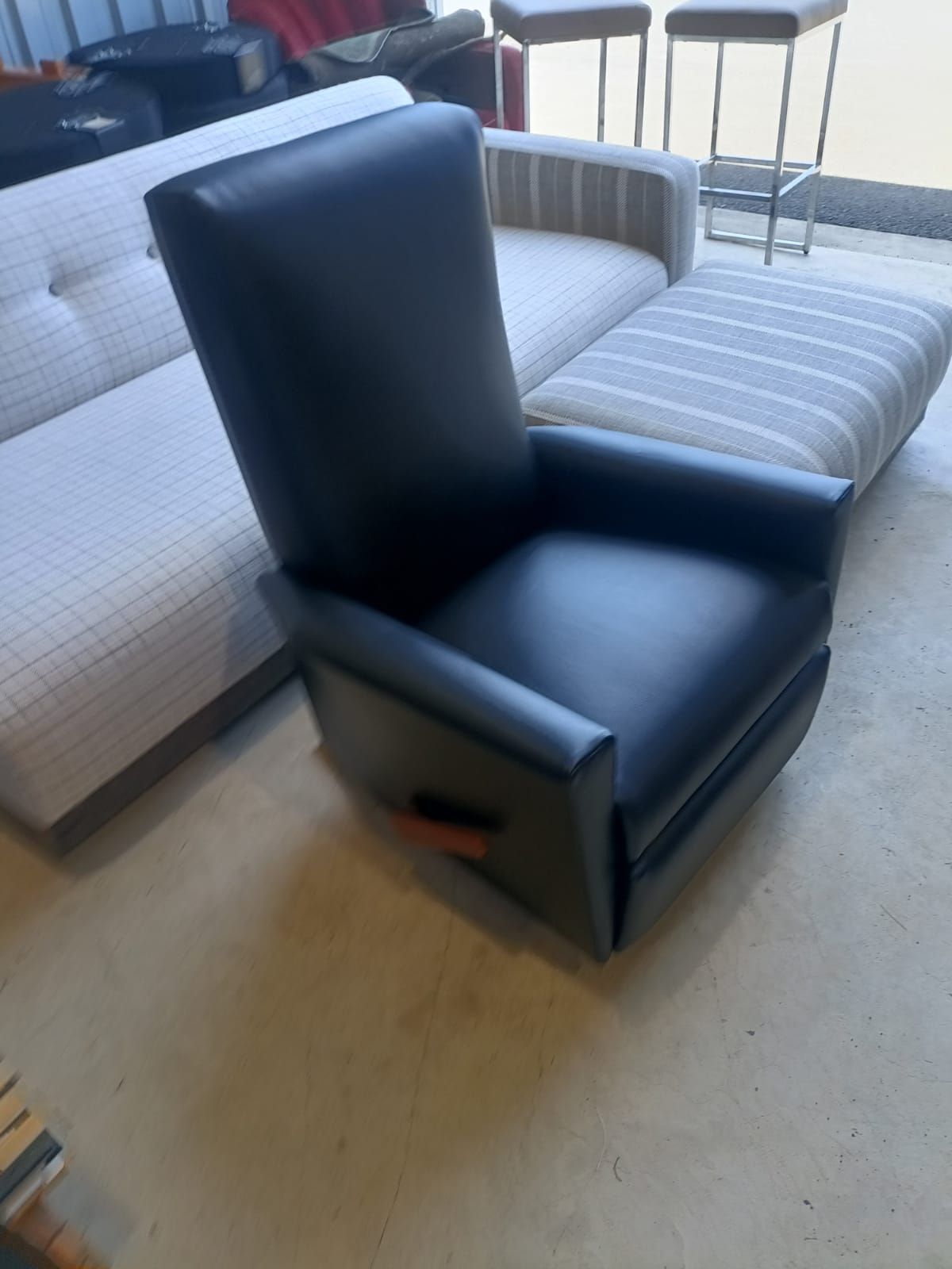 A Black Leather Chair Is Sitting In A Living Room  — Ocean Charm Upholstery In Southport, QLD