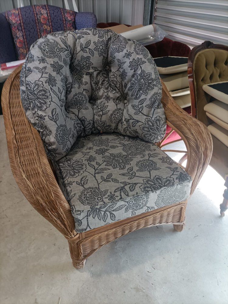 A Wicker Chair With A Cushion On It Is Sitting On A Cement Floor  — Ocean Charm Upholstery In Southport, QLD