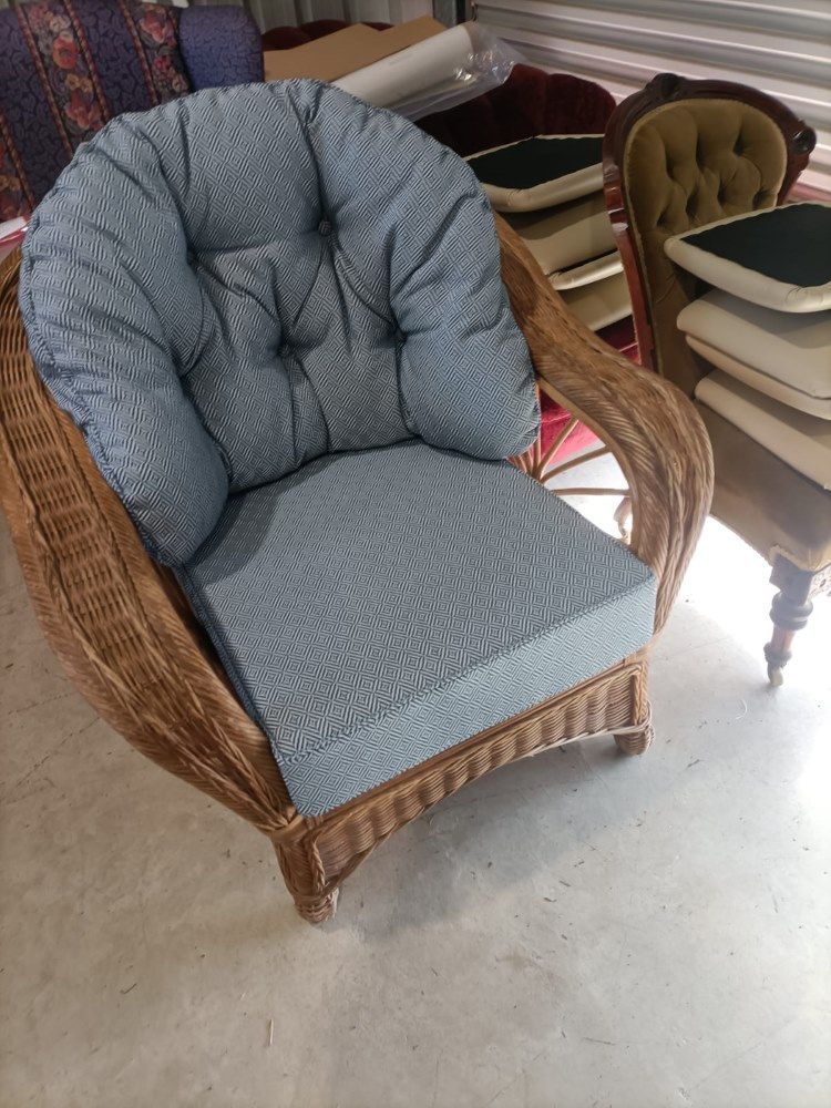 A Wicker Chair With A Blue Cushion Is Sitting In A Room — Ocean Charm Upholstery In Southport, QLD