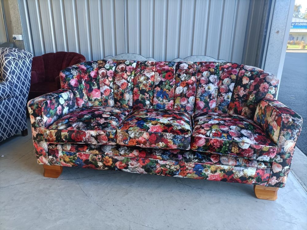 A Colorful Couch With A Floral Pattern Is Sitting In A Garage Next To A Chair — Ocean Charm Upholstery In Southport, QLD