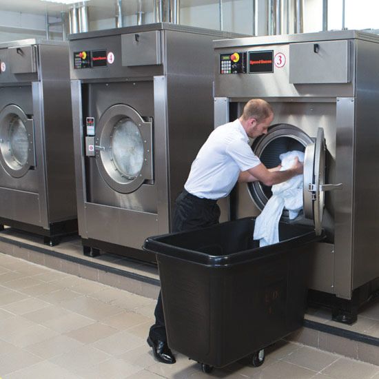 Laundry equipment in use for hotel and nursing home cleaning services by Foy Distribution.