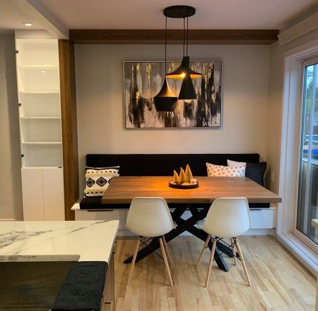 Une salle à manger avec une table et des chaises et un tableau sur le mur