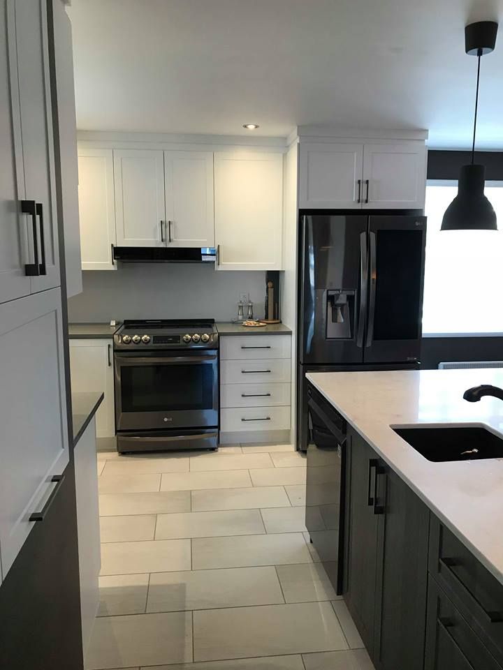 Une cuisine avec des appareils électroménagers en acier inoxydable et des armoires blanches