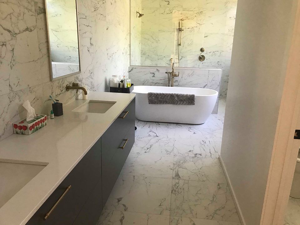 Une salle de bain avec baignoire, lavabo, miroir et douche à l'italienne.