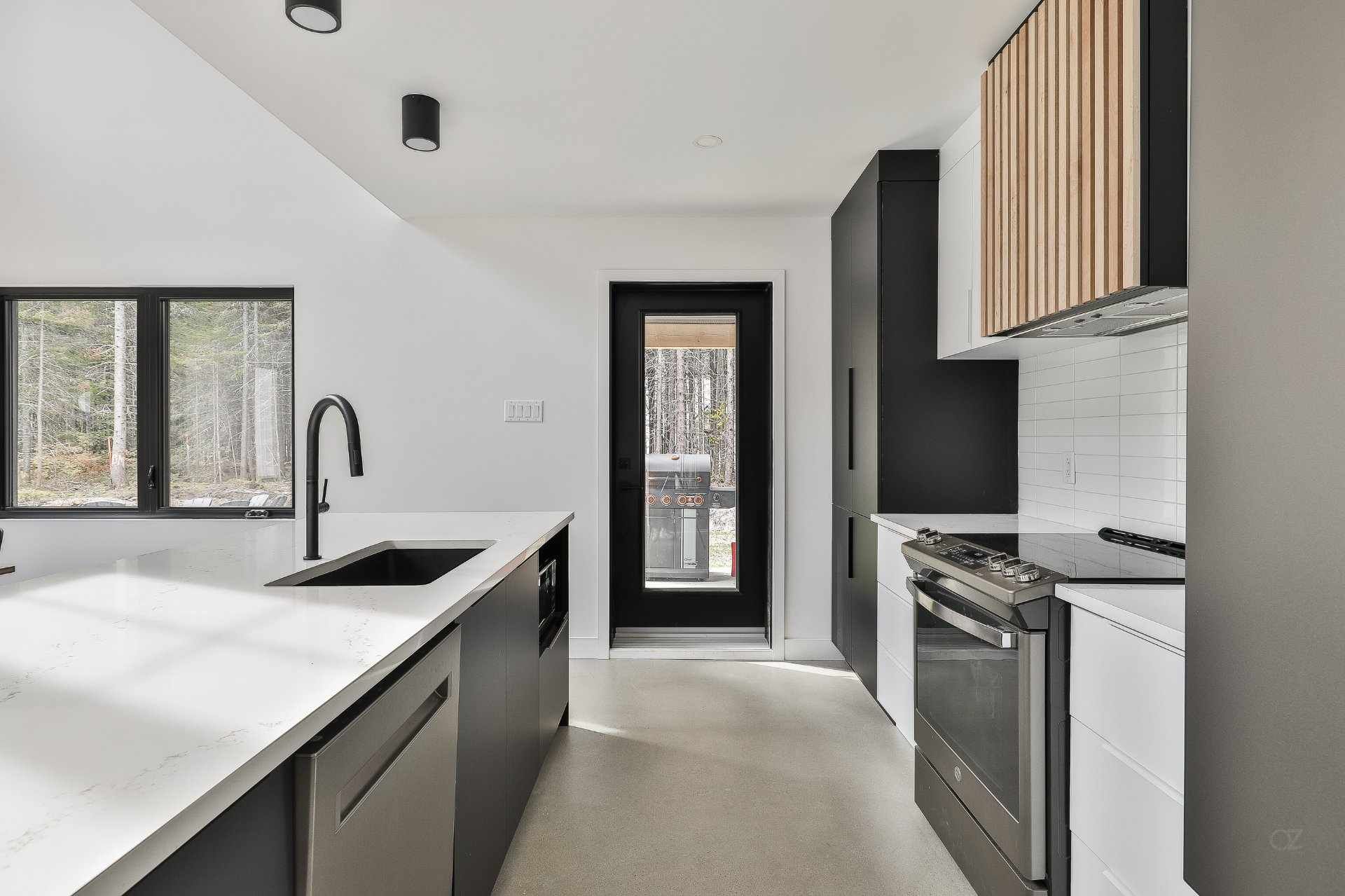 Une cuisine avec des appareils en acier inoxydable, un évier et une cuisinière.