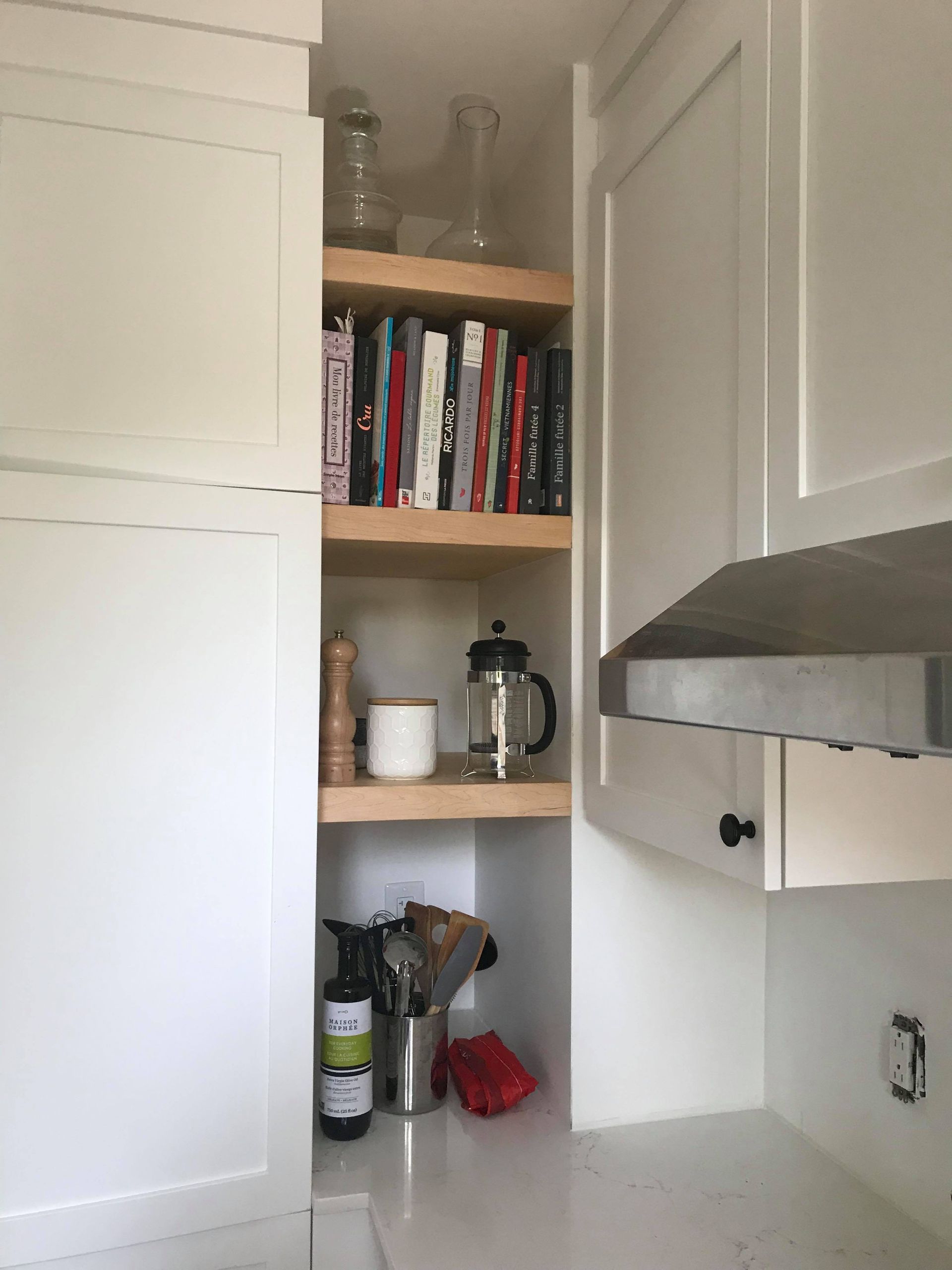 Une cuisine avec une étagère pleine de livres et d'ustensiles