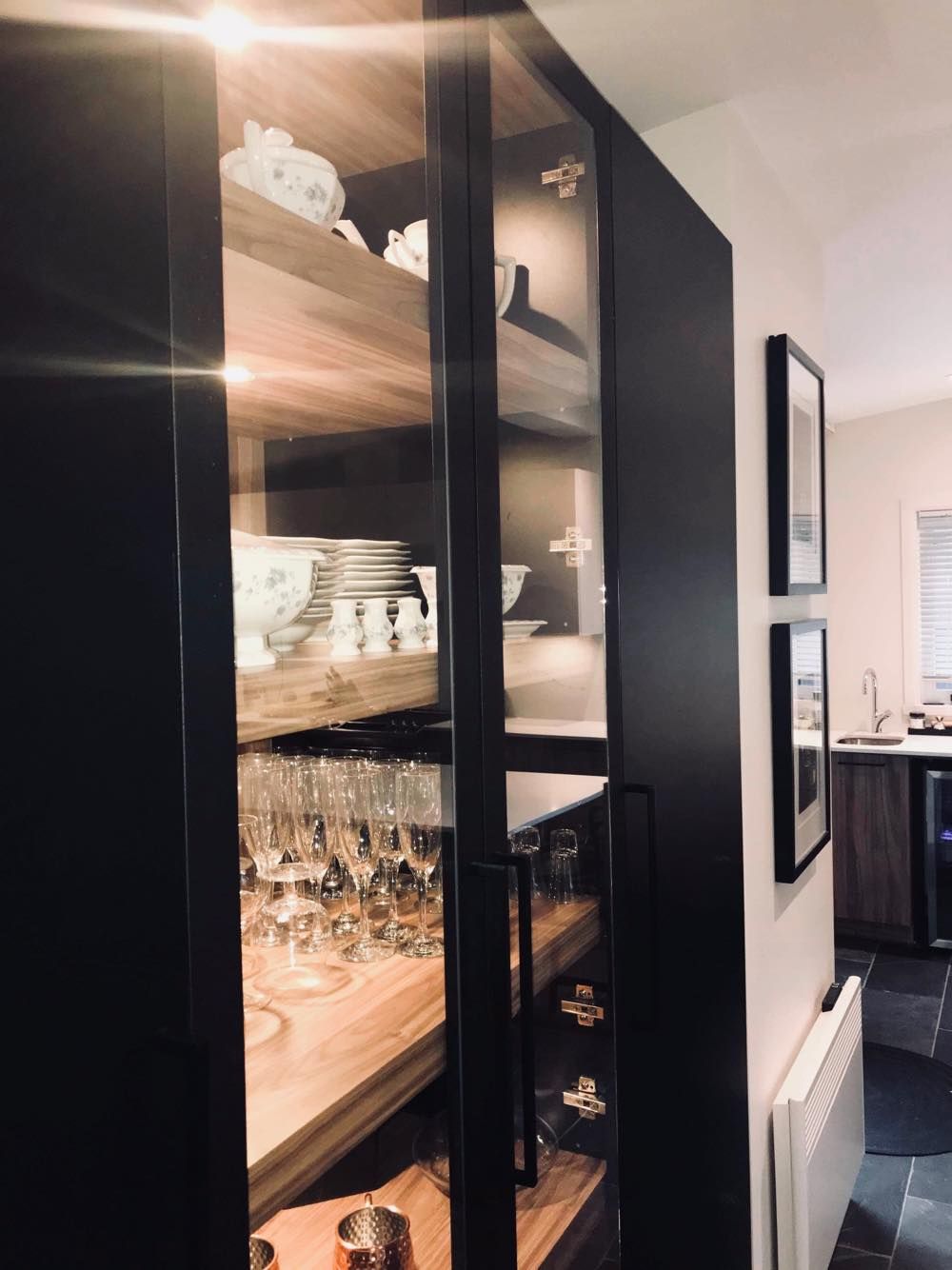 Une cuisine avec une porte vitrée remplie d'assiettes et de verres