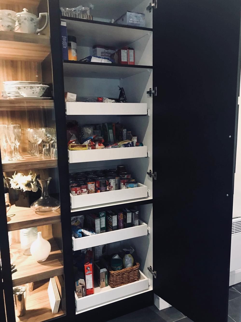 Un garde-manger avec beaucoup de nourriture dedans et une porte vitrée.