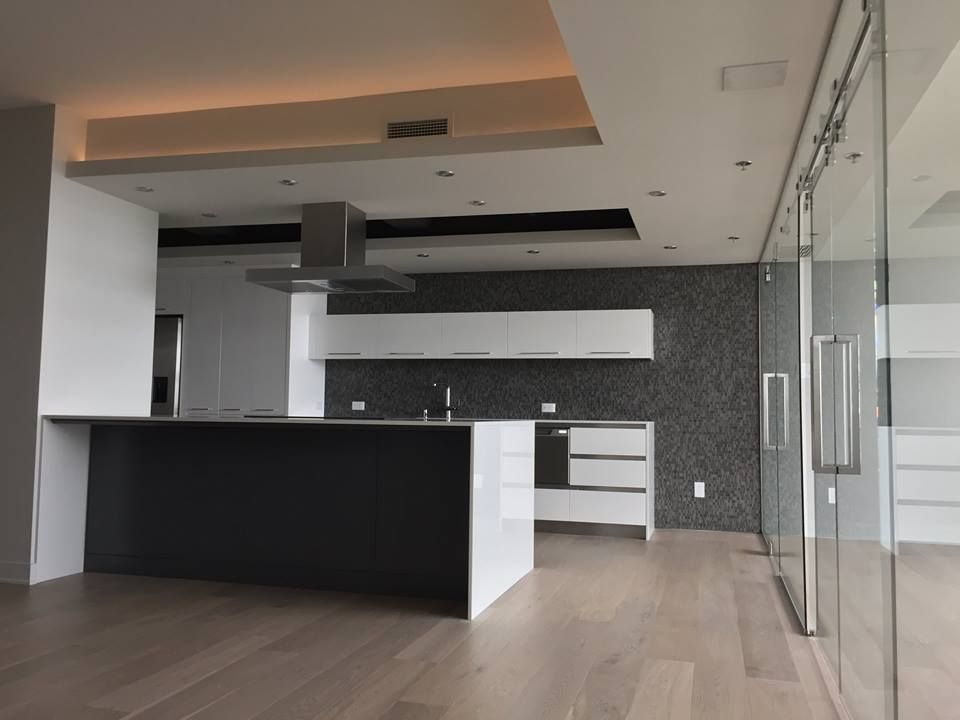 Une cuisine avec un grand îlot et des portes coulissantes en verre