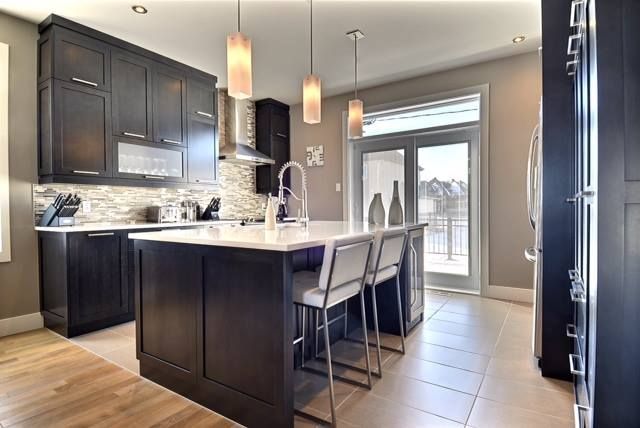 Une cuisine avec un grand îlot et des tabourets