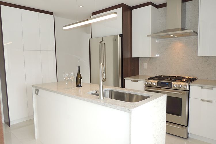 Une cuisine avec des armoires blanches et des appareils électroménagers en acier inoxydable