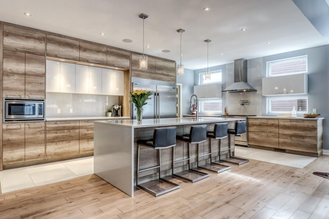 Une cuisine avec des armoires en bois, des électroménagers en acier inoxydable et un grand îlot.