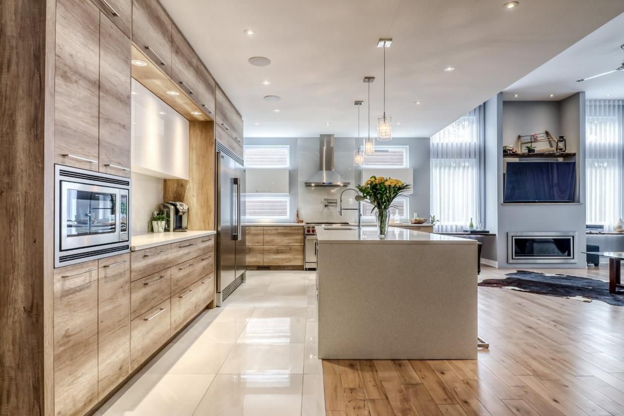 Une cuisine avec des armoires en bois, des électroménagers en acier inoxydable et un grand îlot.