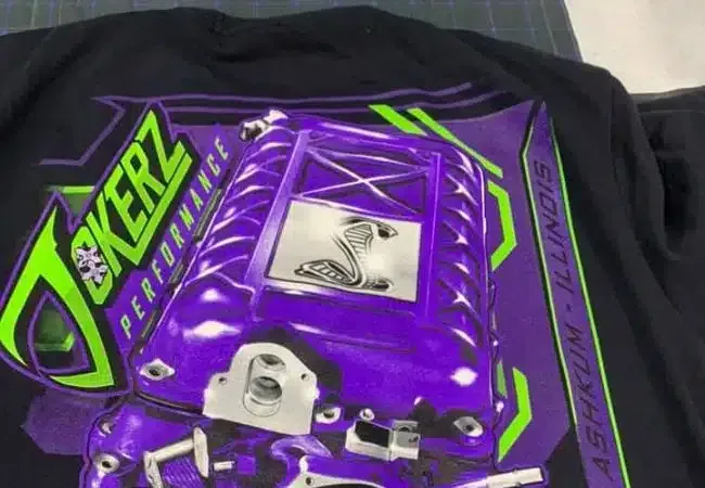 A black shirt with a purple jokerz performance logo on it