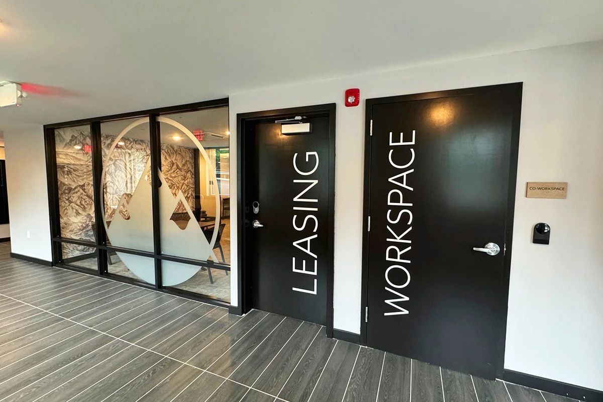 A hallway with black doors that say leasing and workspace.