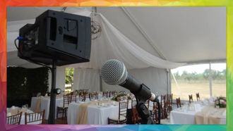Microphone and speaker set up in tent at an event with decorated tables.