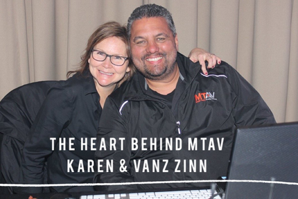 Karen and Vanz Zinn smiling, embracing, posing in front of a backdrop, text reads “The Heart Behind MTAV”.