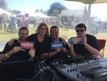 Four people at an event, holding signs that say 