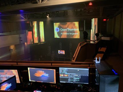 View from a control room of a stage with the Grant Thornton logo displayed on a screen.