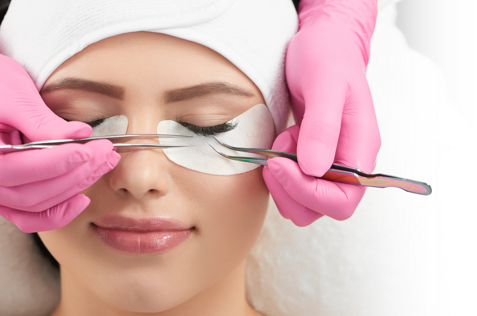A woman is getting eyelash extensions in a beauty salon.