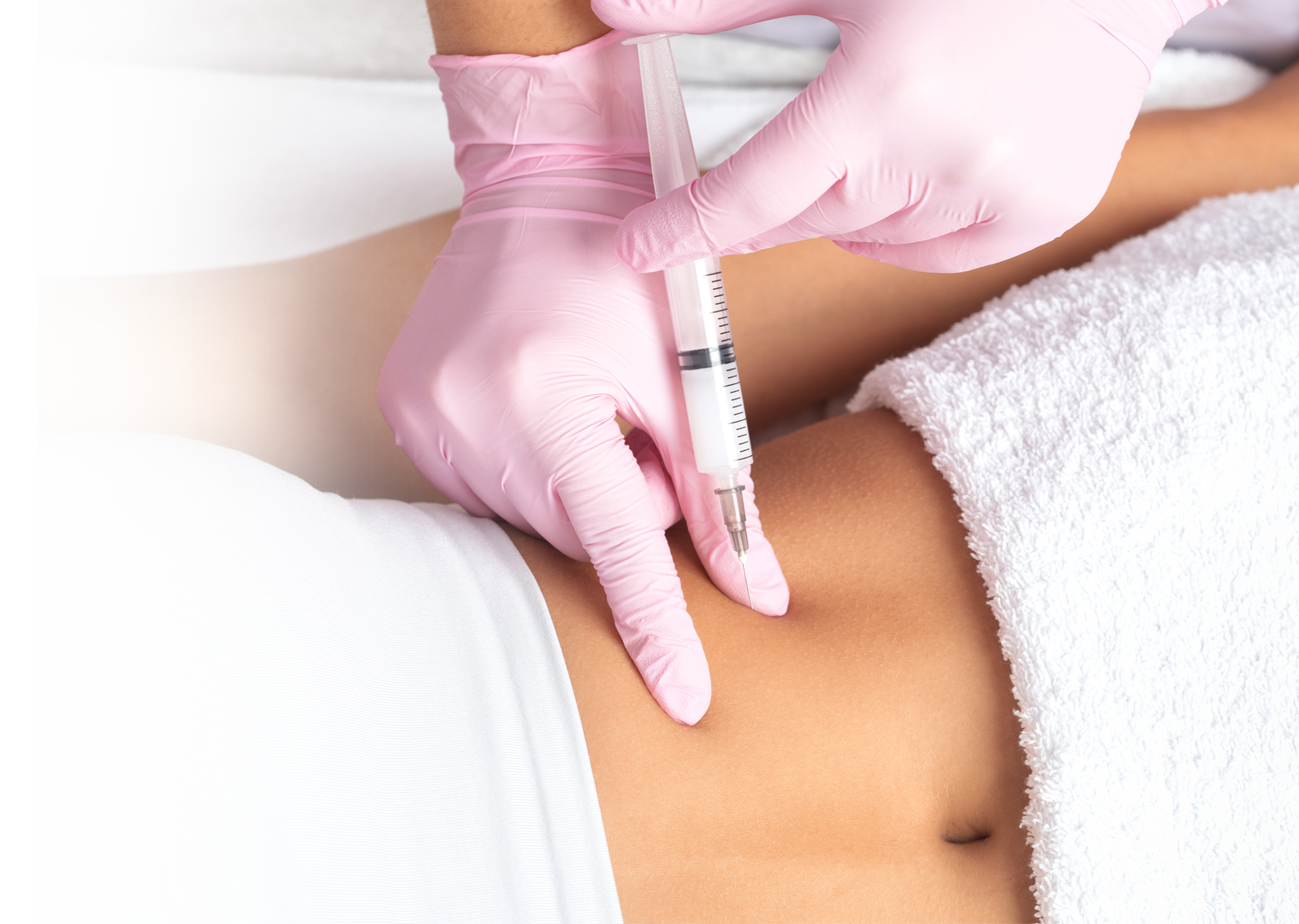 A woman is getting an injection in her stomach.